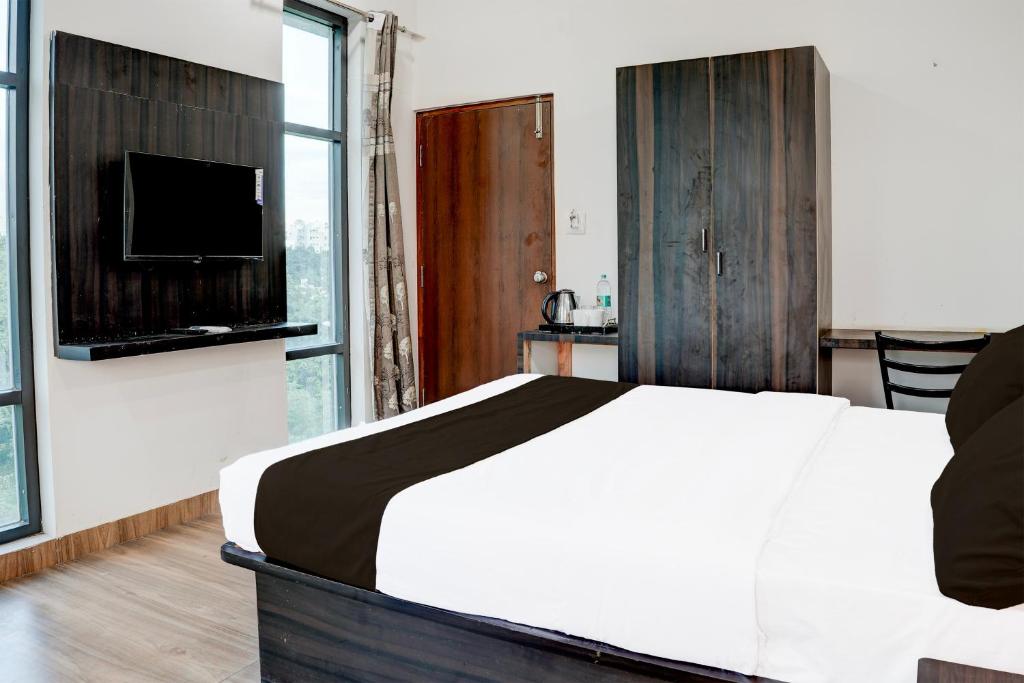 ein Schlafzimmer mit einem großen Bett und einem Fernseher in der Unterkunft Hotel O Royal galaxy suites in Bangalore