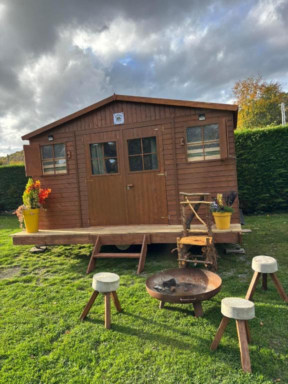 a tiny house with a grill and two stools at ArdennenHut on Wheels in Durbuy