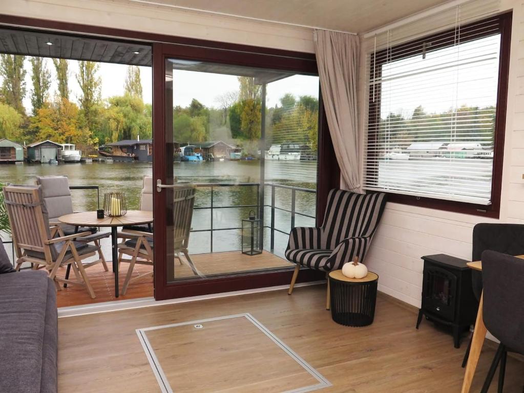 een afgeschermde veranda met een tafel en stoelen bij Houseboat Rosie in Praag