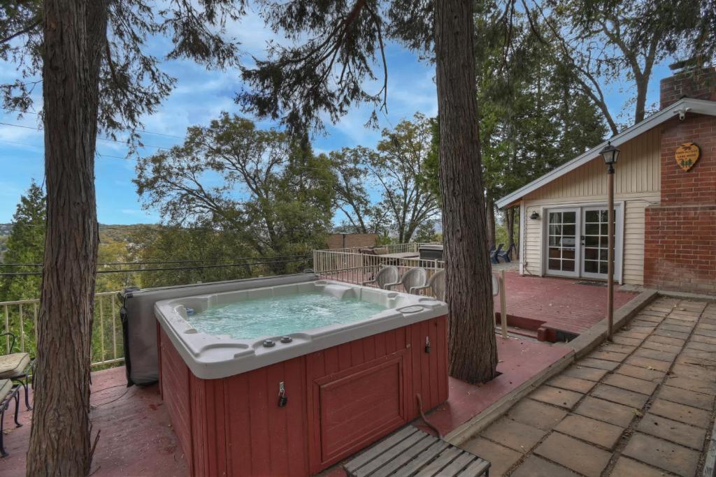 a hot tub on a patio with trees at Emerald Arrowhead Haus - For 6 in Lake Arrowhead