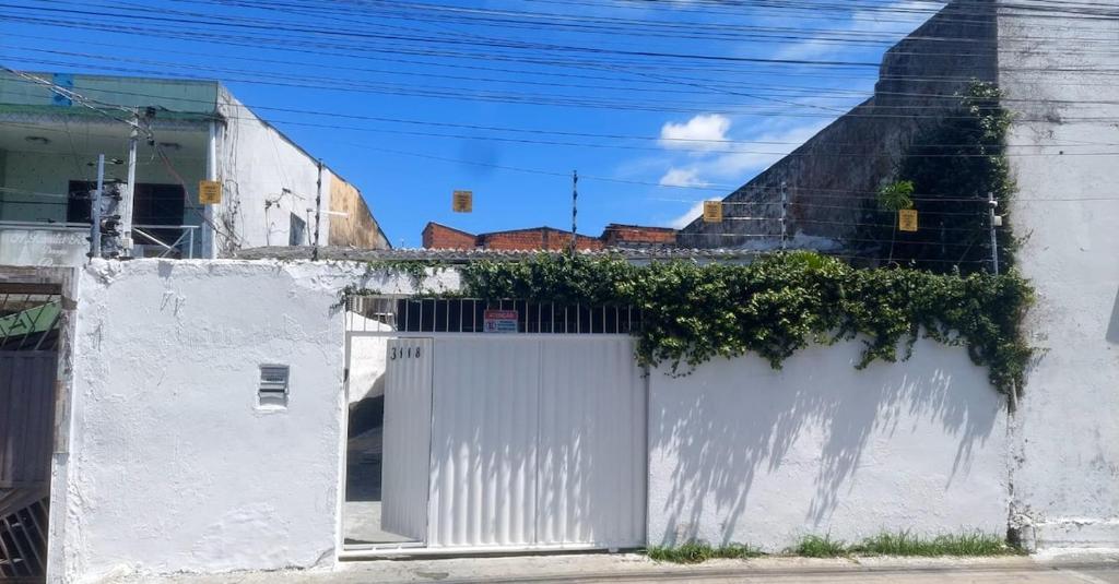 ein weißer Zaun mit Efeu darauf in der Unterkunft COP 30 Casa para grupos in Água Boa