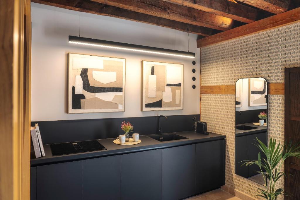 a kitchen with a black counter and a sink at Hotel Spa Los Mercaderes in Talavera de la Reina