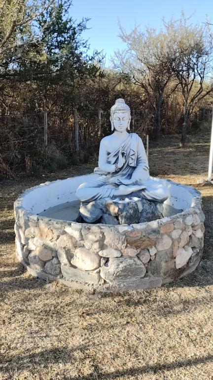 a statue of aitatingitating woman sitting in a fountain at Antar Mouna in Cortaderas