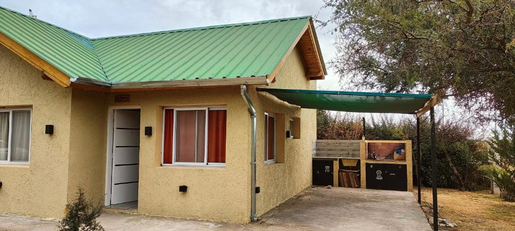 a small yellow house with a green roof at Antar Mouna in Cortaderas