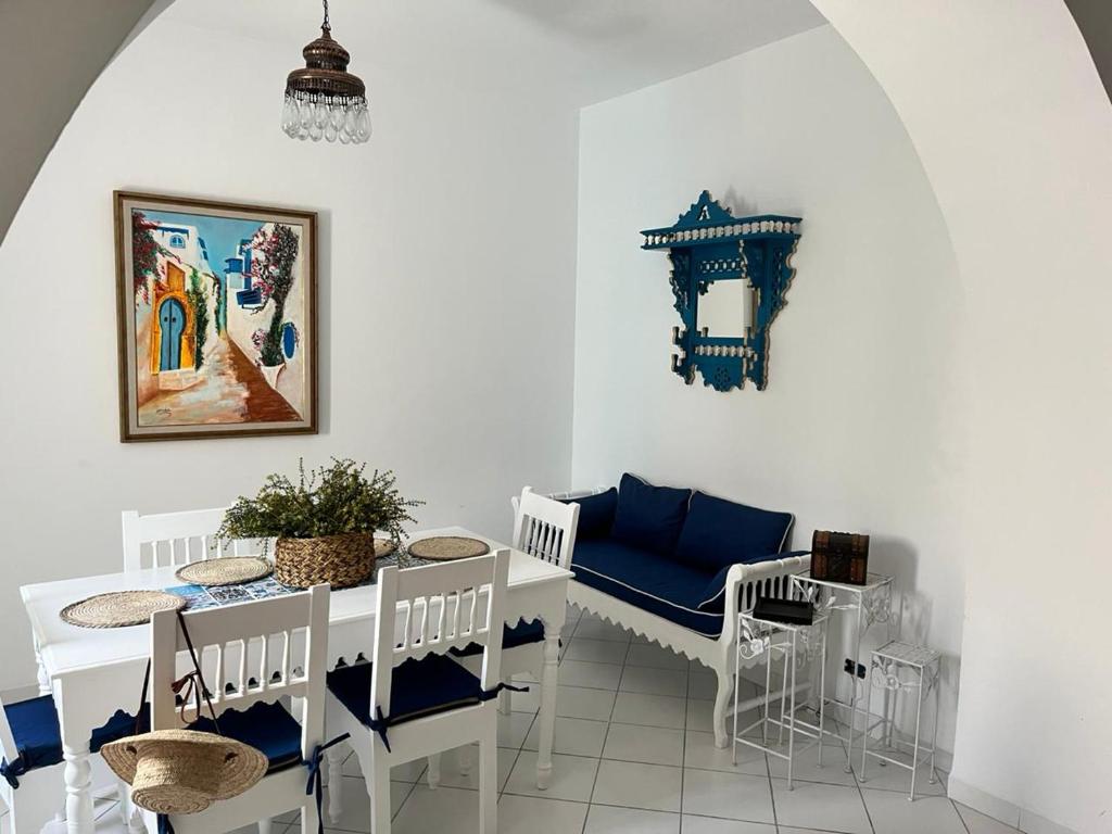 a dining room with white chairs and a table at Villa Nouryan l'Azur of Carthage in La Marsa
