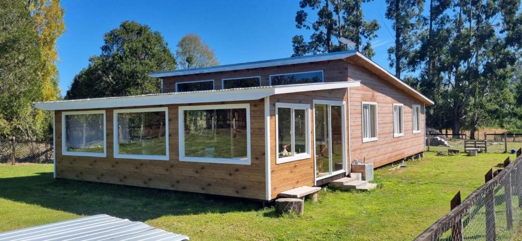 a tiny house on a yard with a fence at Cabaña Alto Puelo in Puelo