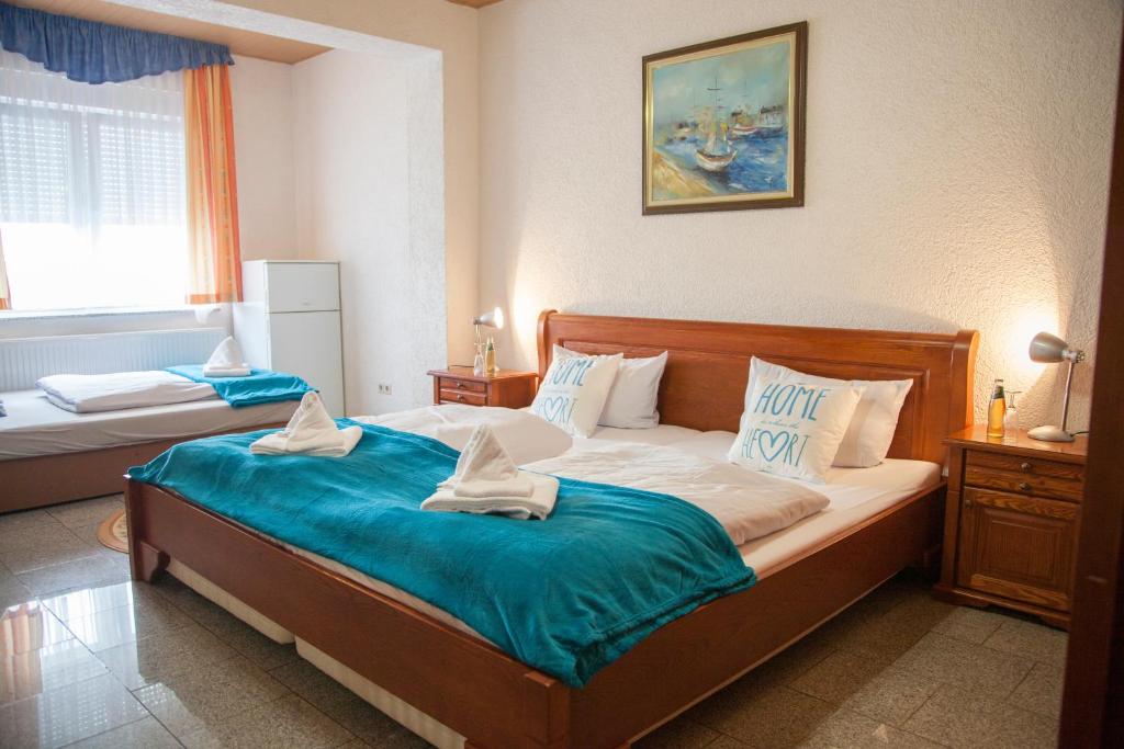 a bedroom with a large bed with blue sheets at Hotel Atlantis in Ramstein-Miesenbach