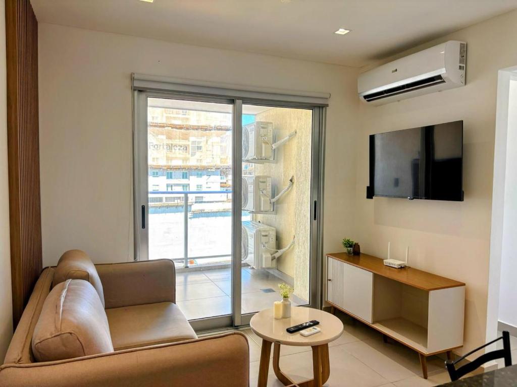 a living room with a couch and a large window at Molas Tower 2 habitaciones in Asuncion
