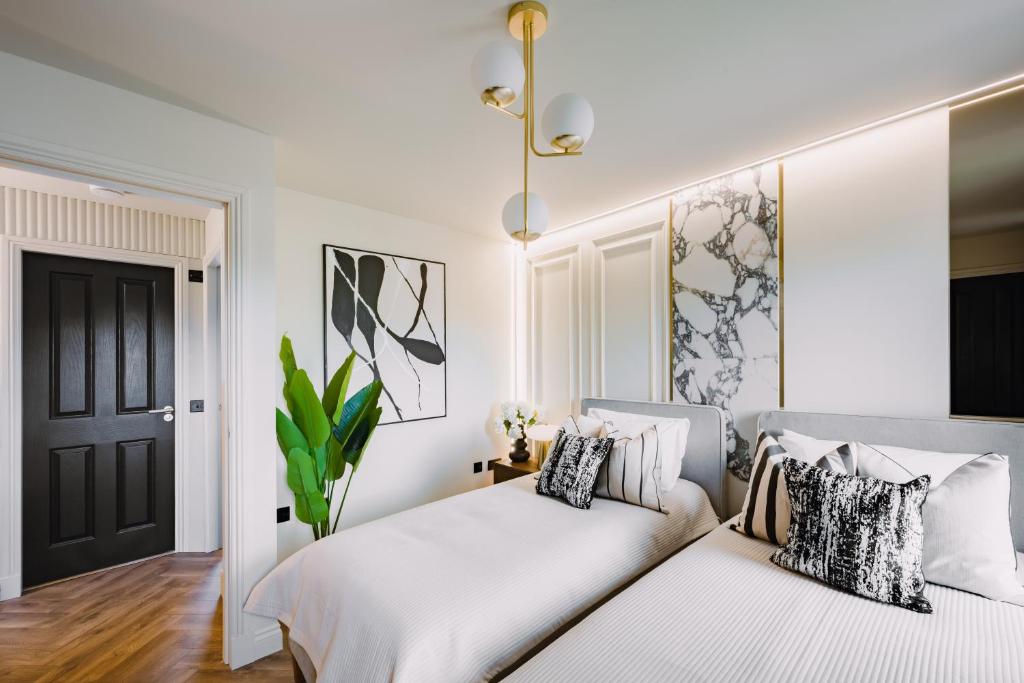 een slaapkamer met 2 bedden en een zwarte deur bij JW Executive ApartHouse in Glasgow