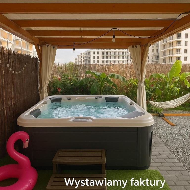 a hot tub sitting under a gazebo at Apartament Koliber Spa in Rzeszów