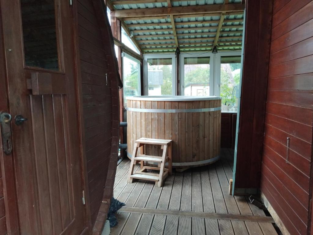a wooden deck with a hot tub and a wooden stool at Maamaja puhkuseks in Kibuna