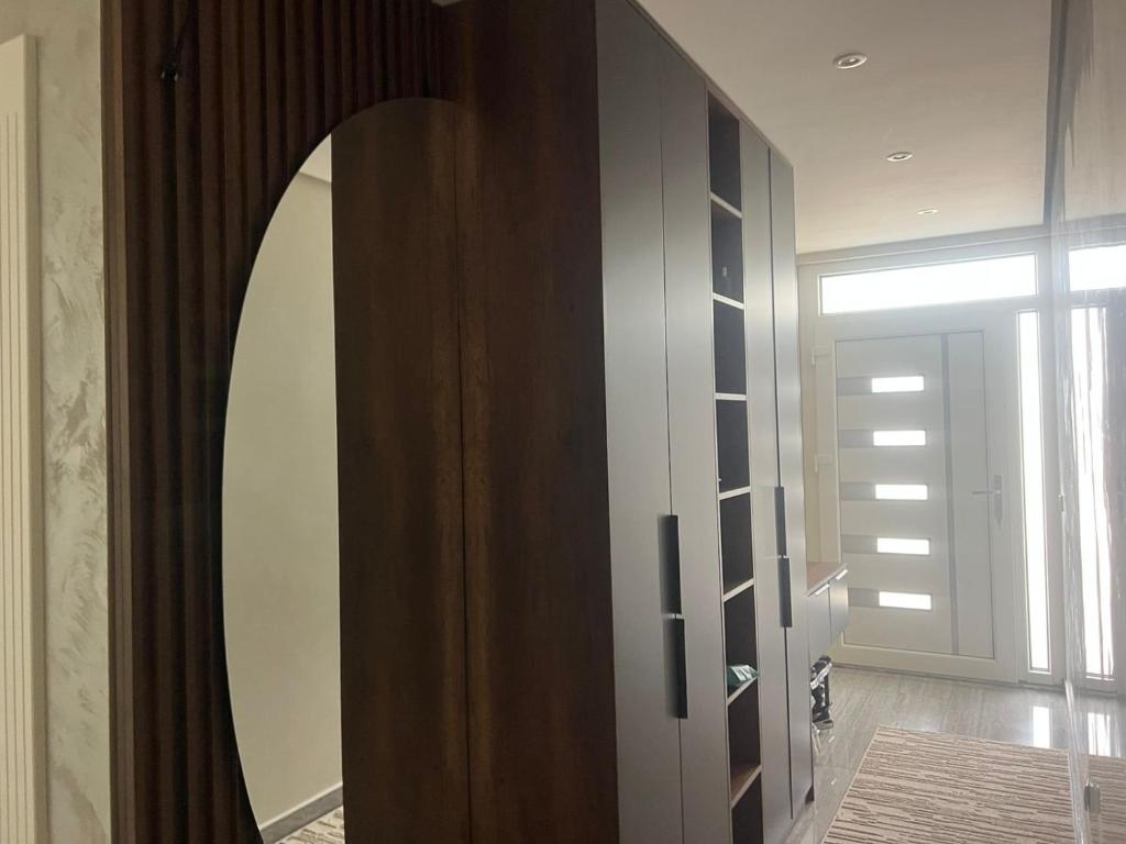 a room with a mirror and a wooden closet at Banesa Mitrovice in Mitrovicë