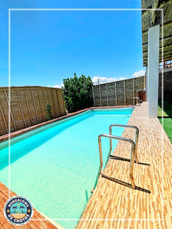a swimming pool with a bench in the water at Bungalows de Chotos in Los Órganos