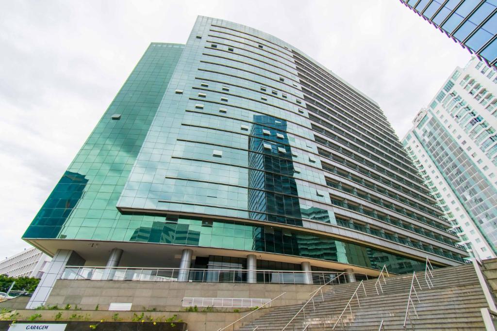 巴西利亚Vision Hotel em Brasília 84573的一座高大的玻璃建筑,前面有楼梯