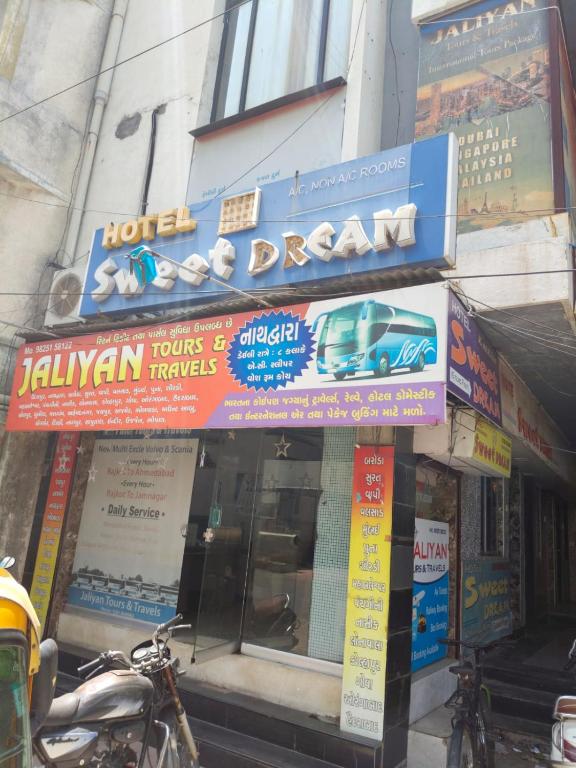 a store with signs on the front of a building at Hotel Dream in Rajkot