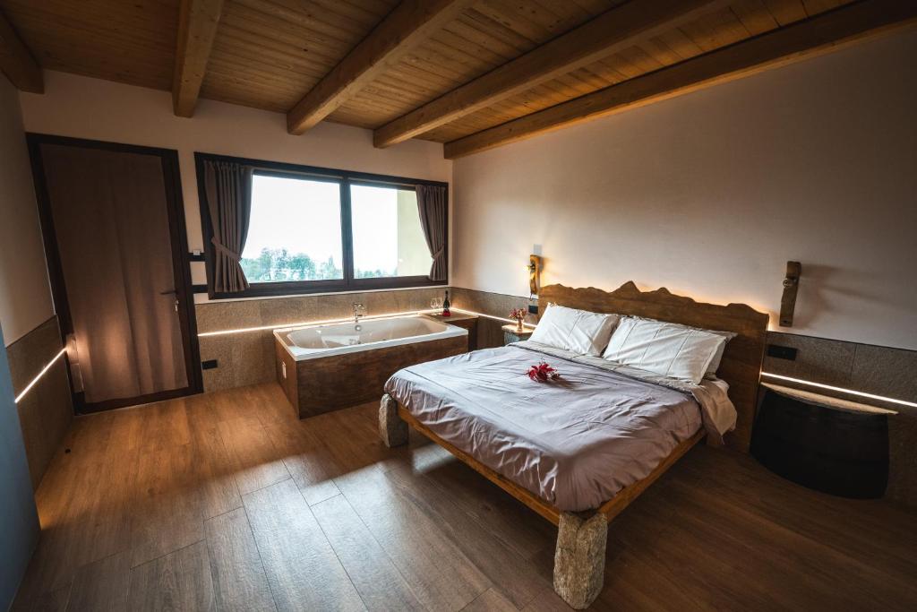 um quarto com uma cama e uma banheira em Agriturismo Dai Dellerba em Pinerolo