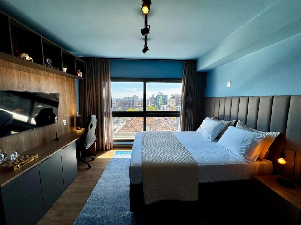 a bedroom with a large bed and a large window at LIV apto 1211 - Loft novo com vista in Porto Alegre