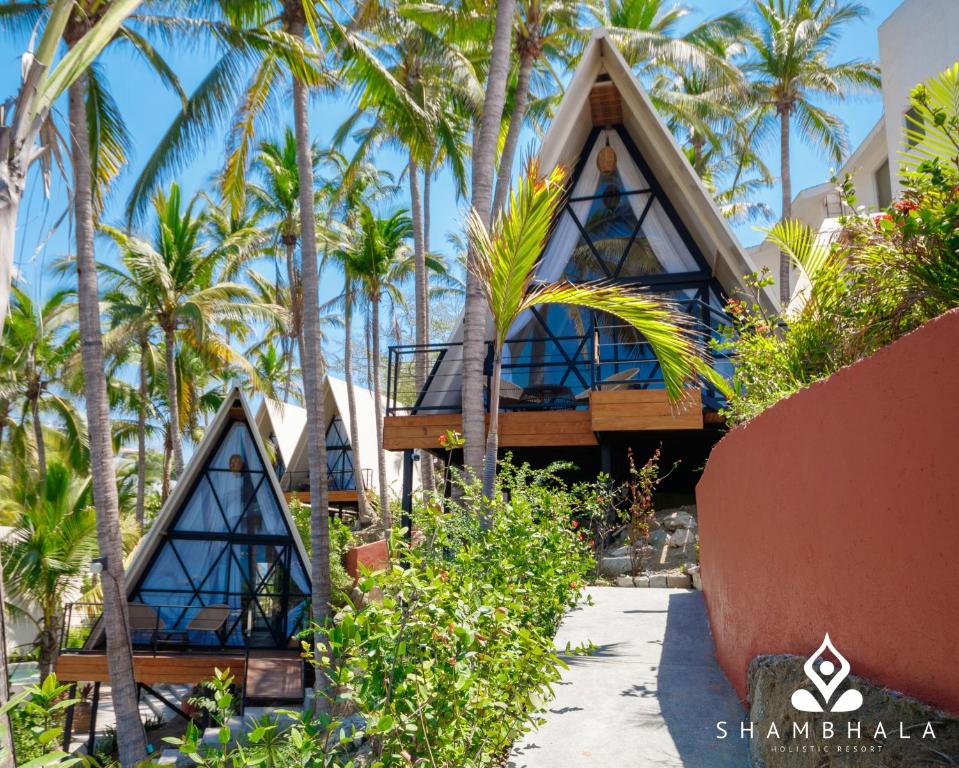 a house on the beach with palm trees at Shambhala Holistic Resort Only Adults in Manzanillo