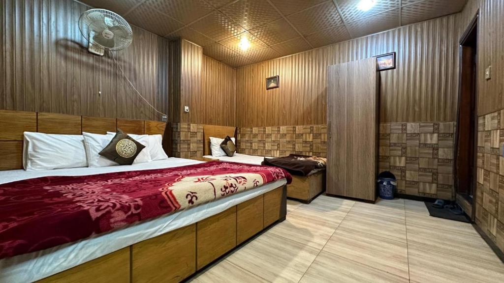 a bedroom with a bed and a fan in it at Baoo Jee Hotel Islamabad in Rawalpindi