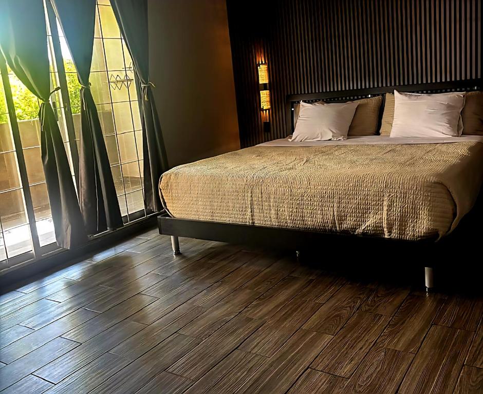 サルティーヨにあるHabitacion Mapleのベッドと木の床のある寝室