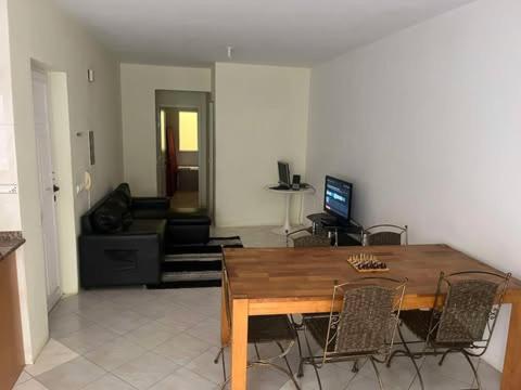 a living room with a wooden table and chairs at 5 minutes from the beach in Mindelo