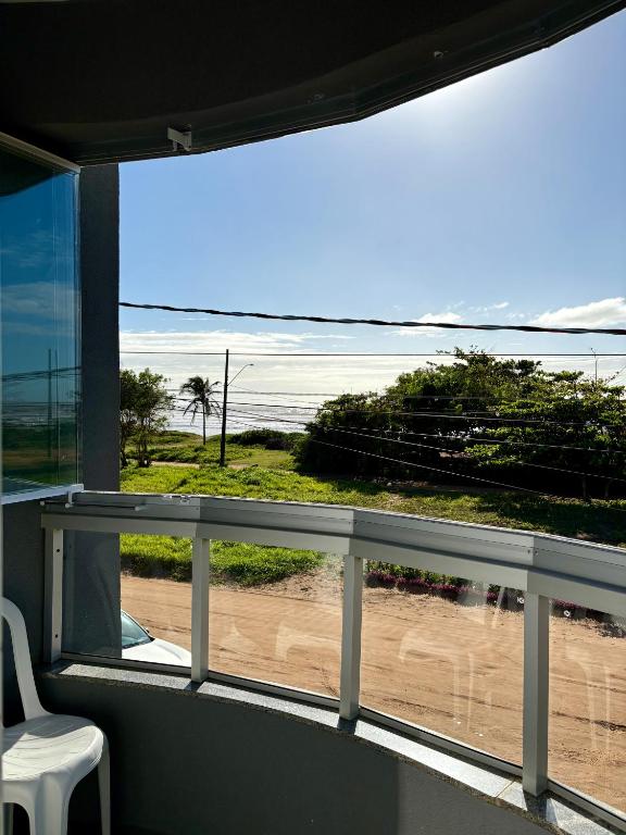 a view of a beach from a balcony with a window at Bertholi Beira-Mar in Serra