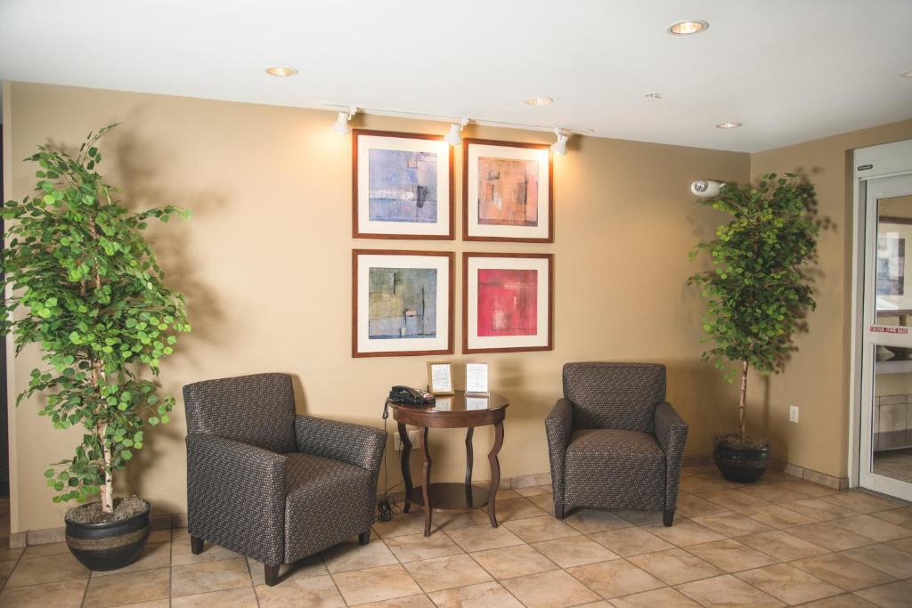 a waiting room with two chairs and potted plants at Candlewood Suites Loveland by IHG in Loveland