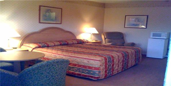 a hotel room with a bed and a table and chairs at Relax Inn Lewisburg in Lewisburg