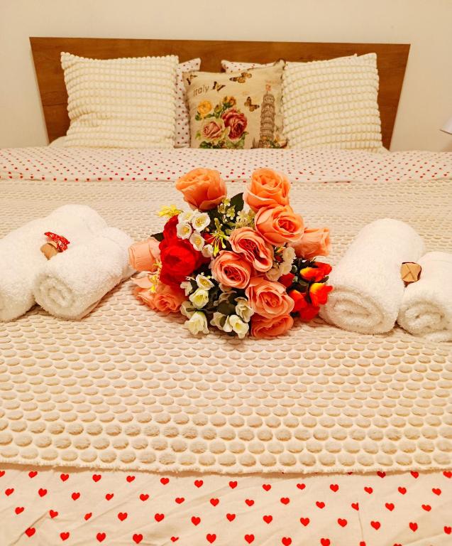 a bouquet of flowers and two stuffed animals on a bed at Home Sweet Home No1 in Belgrade