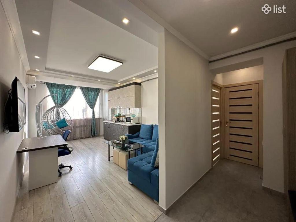 a living room with a blue couch and a kitchen at Apartment Zaqyan street in Yerevan