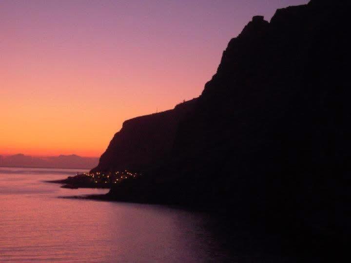 a sunset over the ocean with a mountain at Suite Bela Vigia 3 in Jardim do Mar