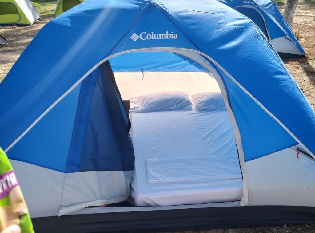 a blue and white tent with a bed in it at Eco camping JASAL in Calabolo