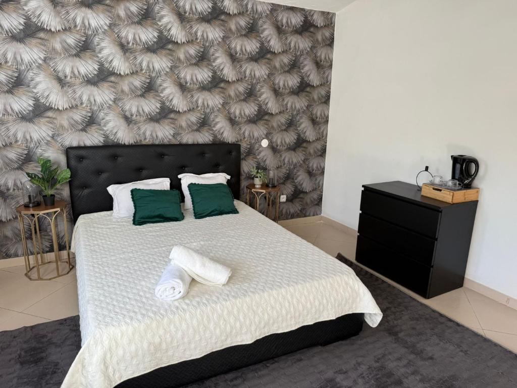 a bedroom with a large bed with two green pillows at Pensão Simão & Júlia - 8 Quartos in Órgãos