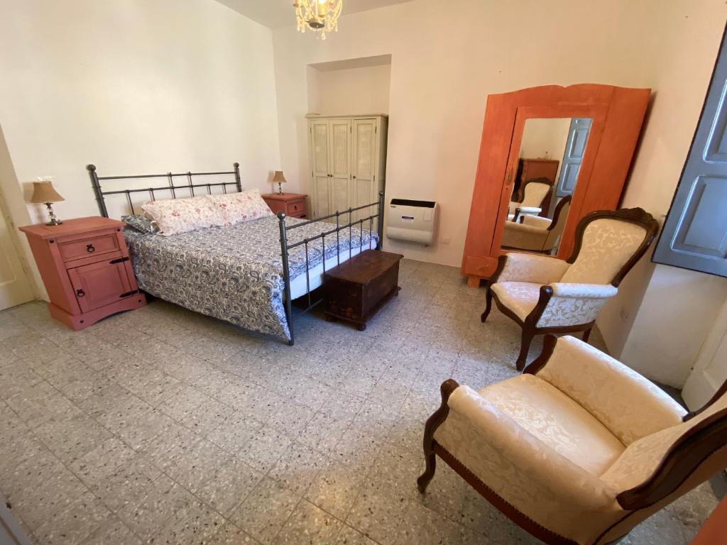 a bedroom with a bed and a chair and a mirror at CASA VACANZA Dimora del tempo in Fara San Martino