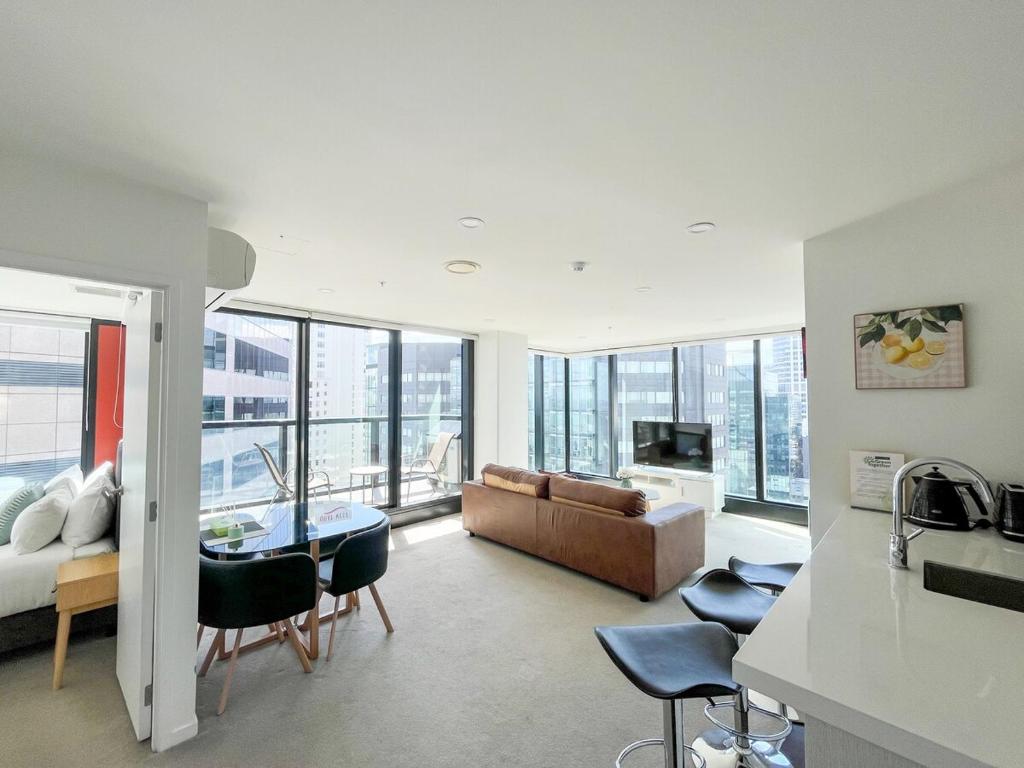 a living room with a couch and a table at Panoramic City View High-Rise 2BR & Skytower-Adj in Auckland