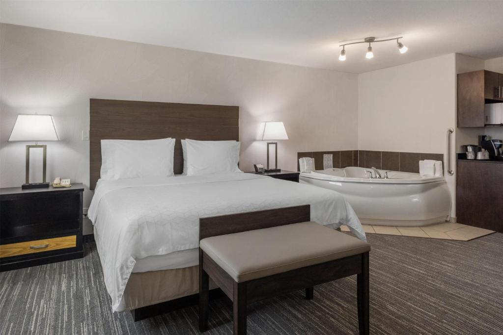 a hotel room with a bed and a bath tub at Best Western Dawson Creek in Dawson Creek