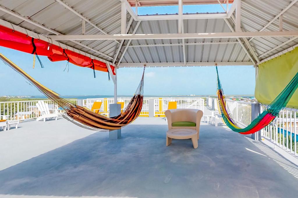 サン・ペドロにあるEastern #8 at Laguna Suite -Gold Standard Certifiedの屋根の上にハンモック2つと椅子がある部屋