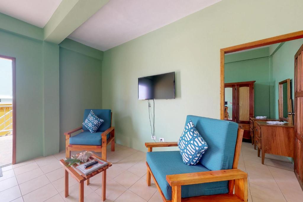 サン・ペドロにあるSara Suite #10 at Laguna Suite -Gold Standard Certifiedの椅子2脚とテレビのあるリビングルーム