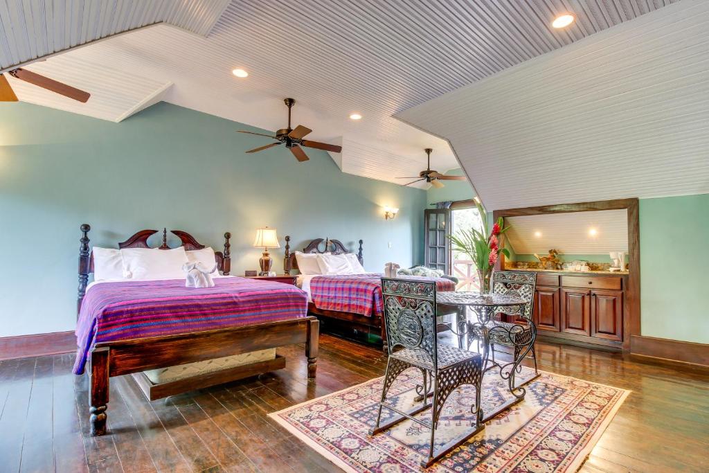 a bedroom with two beds and a table at Monkey Suite at Mahogany Hall -Gold Standard Certified in Bullet Tree Falls