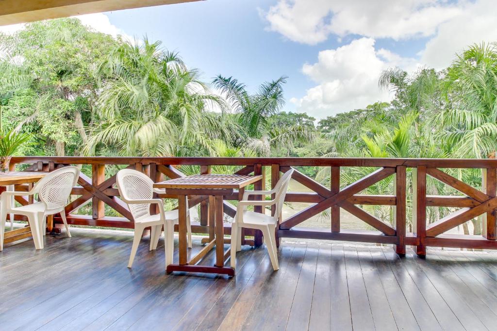 a wooden deck with a table and chairs on it at Parrot Room at Mahogany Hall -Gold Standard Certified in Bullet Tree Falls