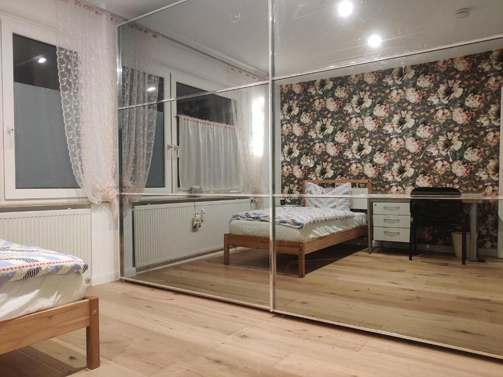 a bedroom with a desk and a glass wall at Einzelzimmer in einer Zweier-Wohngemeinschaft in Bückeburg
