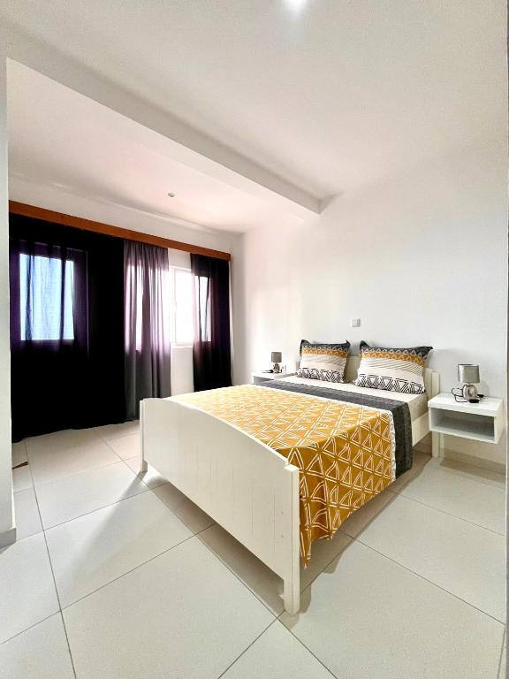 una camera da letto con un letto grande con una coperta gialla di Oásis de retour a Ponta do Sol