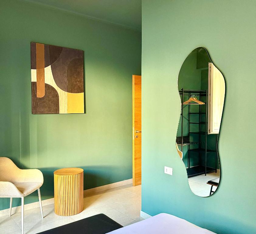 a room with a mirror on a green wall at L'Atelier - 2 min walk to Bernina Express in Tirano