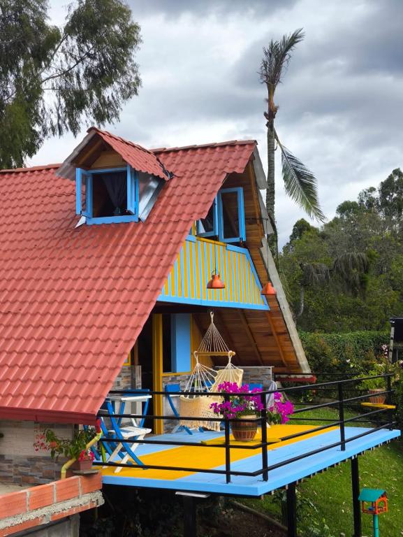 a house with a red roof and a blue balcony at Cabaña El Jericoano in Jericó