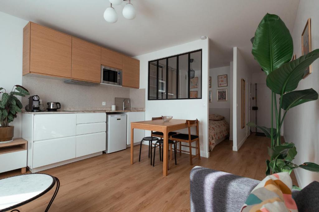 a kitchen and living room with a table and chairs at Studio Cosy - Bas Montreuil in Montreuil