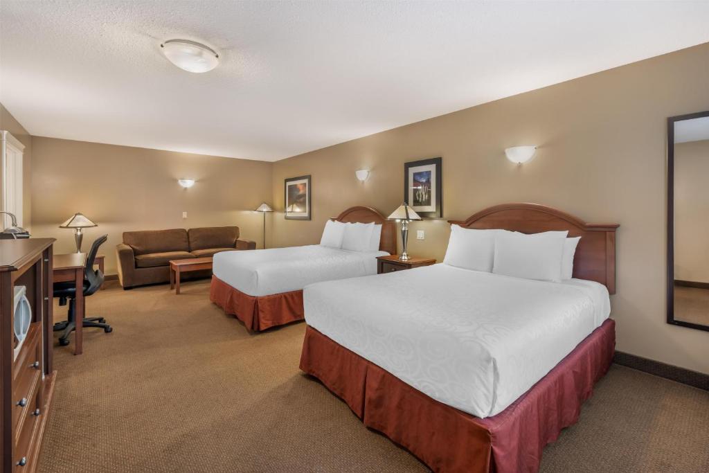 a hotel room with two beds and a couch at Best Western Sicamous Inn in Sicamous