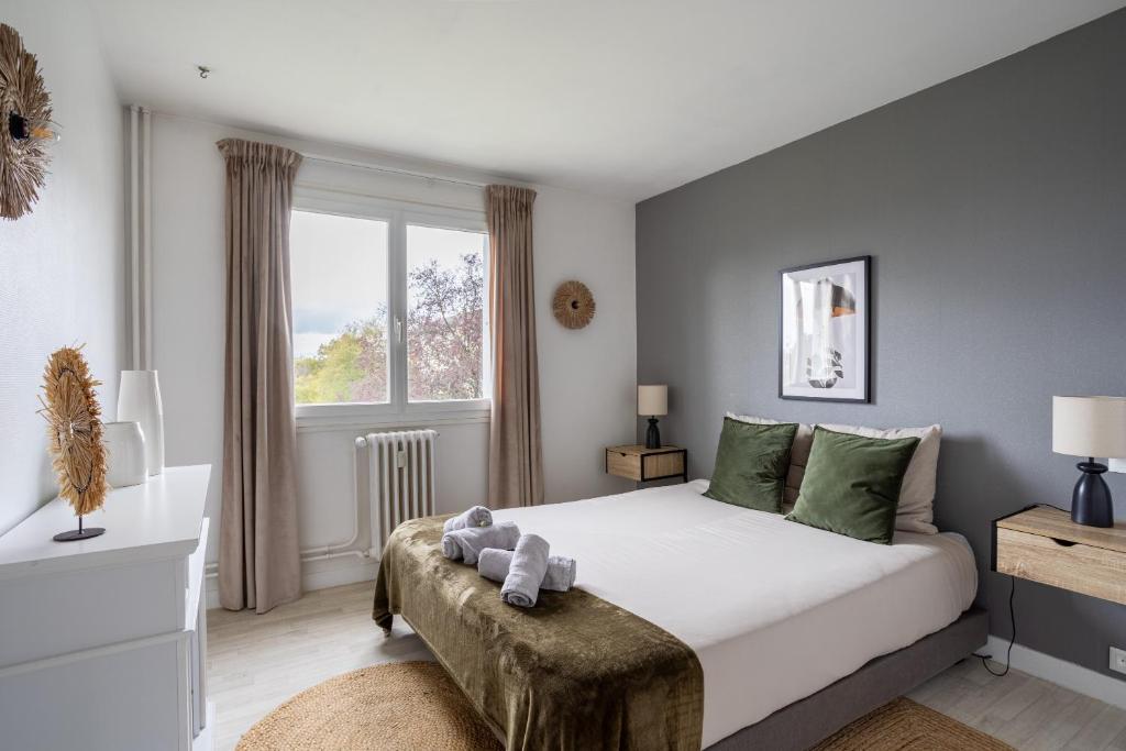 a bedroom with a large white bed and a window at La Butte Enchantée - Wifi Fibre TV - Baignoire - Cosy in Saint-Sébastien-sur-Loire