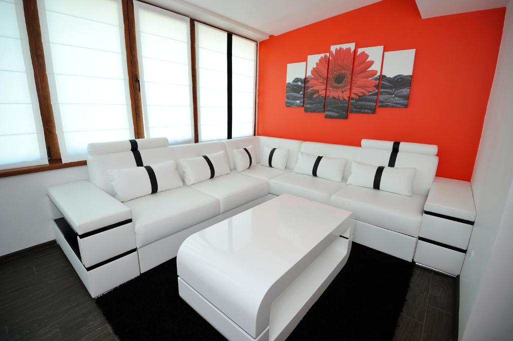ヴァルナ・シティにあるPoshta 1 Apartment 1の白いソファと赤い壁のリビングルーム