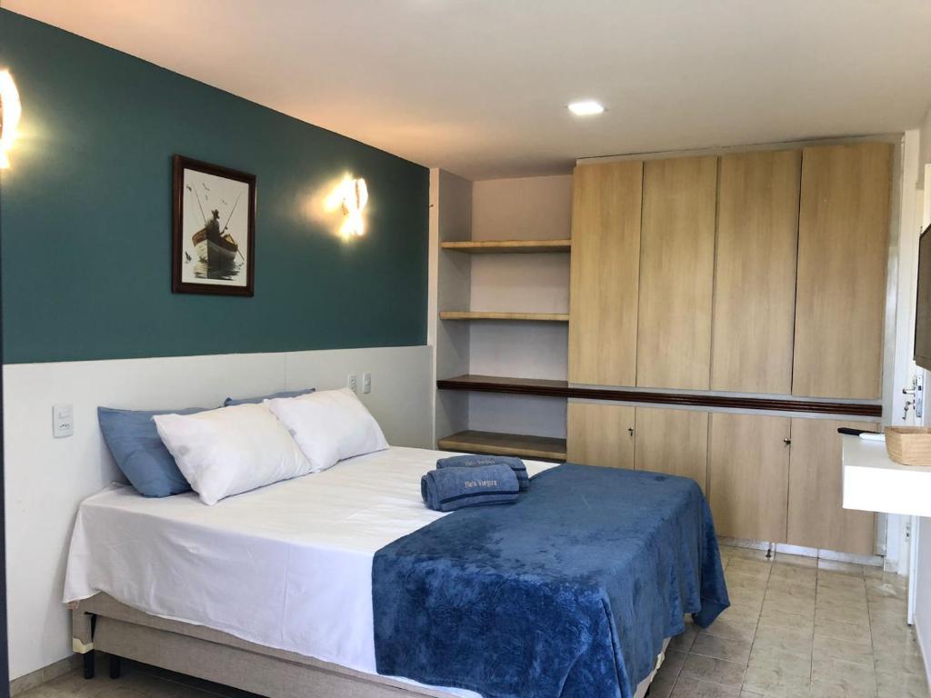 a bedroom with a bed and a green wall at Flat Aconchegante em Ponta de Campina in Cabedelo