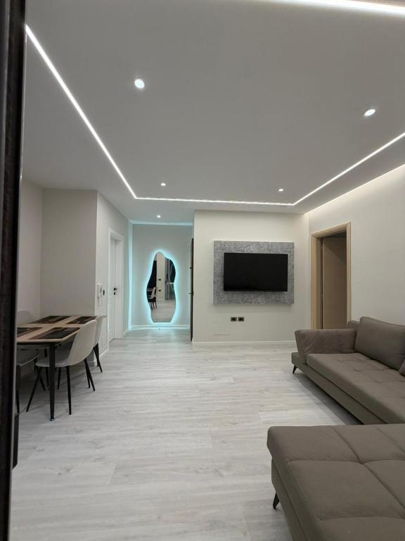 a living room with a couch and a table at Chic Apartament Free Parking in Vlorë